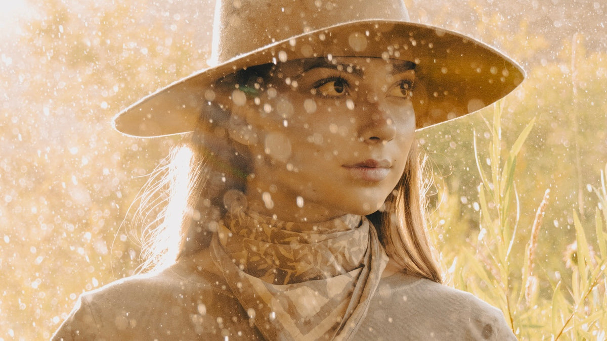 Person wearing a wide-brimmed hat in a snowy landscape