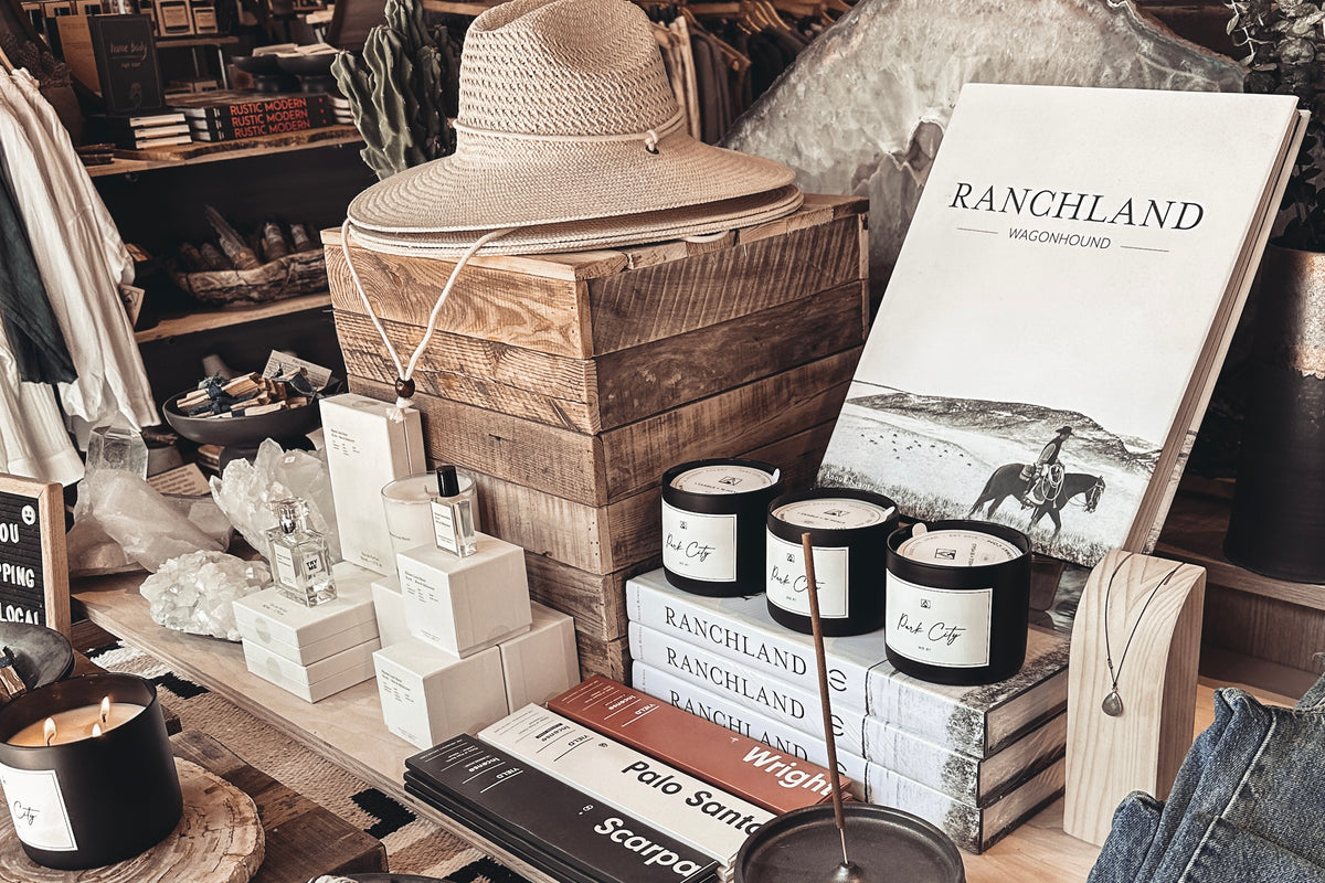 Display of candles, books, and a hat in a rustic setting